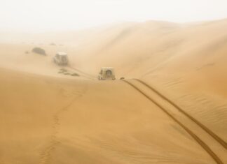 Namibia na własną rękę szlakiem wydm, pustyń i dzikich zwierząt Dwa auta terenowe jadą przez rozległe wydmy w Namibii, region Hardap